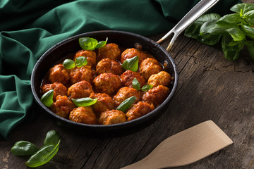 Traditional italian Meatballs served on a old wooden table. Meatballs served on a old wooden table with green napkin and spoon. Homemade delicious italian Meatballs on on a rustic table for dinner. it