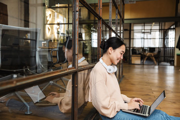 Image of young beautiful asian woman working on laptop in office