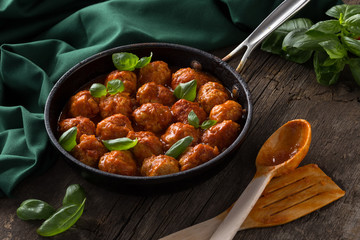 Traditional italian Meatballs served on a old wooden table. Meatballs served on a old wooden table with green napkin and spoon. Homemade delicious italian Meatballs on on a rustic table for dinner. it