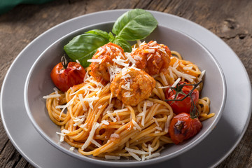 Traditional italian pasta served on a old wooden table. Pasta with Meatballs, parmesan cheese and herbs. Homemade delicious italian traditional pasta on on a rustic table for dinner. italian cuisine.