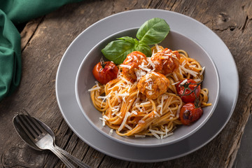 Traditional italian pasta served on a old wooden table. Pasta with Meatballs, parmesan cheese and herbs. Homemade delicious italian traditional pasta on on a rustic table for dinner. italian cuisine.