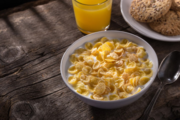 Breakfast with cereal. Flakes with milk. A plate of cereal with milk on a old wooden table. Perfect for breakfast. Free space for text.