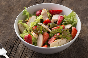 Caesar salad. Caesar salad with fresh lettuce, parmesan, fried croutons, chicken and strawberries. Restaurant food, close up. Meat salad. Close up view.