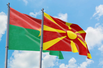Macedonia and Burkina Faso flags waving in the wind against white cloudy blue sky together. Diplomacy concept, international relations.