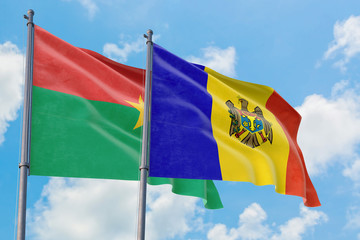 Moldova and Burkina Faso flags waving in the wind against white cloudy blue sky together. Diplomacy concept, international relations.
