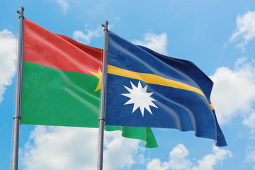 Nauru and Burkina Faso flags waving in the wind against white cloudy blue sky together. Diplomacy...