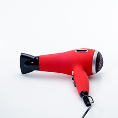 Red hair dryer on the white matt background