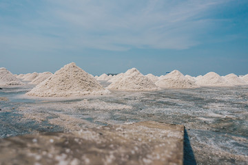 Many white salt piles in Salt farm Thailand with blue sky