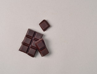 pieces of dark chocolate on grey background