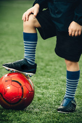 feet of a boy on a soccer ball