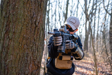 Fototapeta premium Male from private military company with rifle in the forest