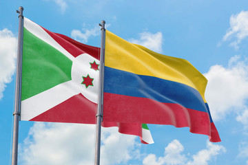 Colombia and Burundi flags waving in the wind against white cloudy blue sky together. Diplomacy concept, international relations.