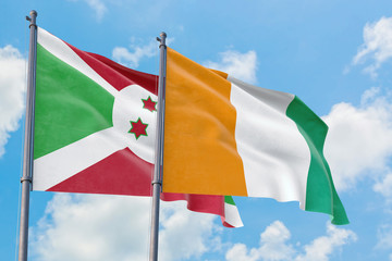 Cote D'Ivoire and Burundi flags waving in the wind against white cloudy blue sky together. Diplomacy concept, international relations.