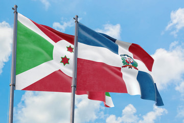Dominican Republic and Burundi flags waving in the wind against white cloudy blue sky together. Diplomacy concept, international relations.