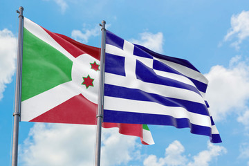 Greece and Burundi flags waving in the wind against white cloudy blue sky together. Diplomacy concept, international relations.