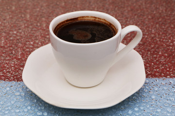 Close-up - a cup of coffee on a red-blue background.