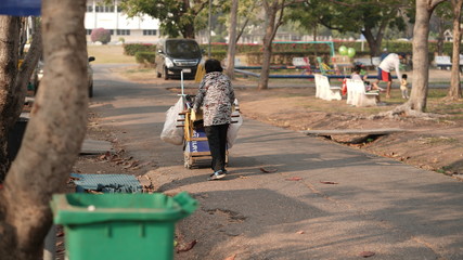 Old Lady Collects Trash in Park 