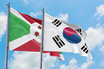 South Korea and Burundi flags waving in the wind against white cloudy blue sky together. Diplomacy concept, international relations.