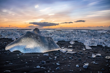 Pieces of ice washed ashore on Diamond Beach, Iceland at sunrise.