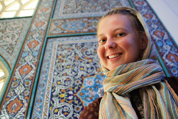 Young girl tourist on the background of the famous Jameh Mosque of Isfahan. Great heritage of Persian architecture, blue mosaic