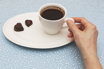 Female hand holds a cup of coffee.