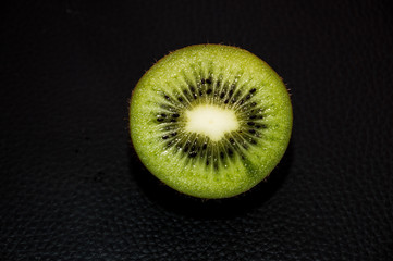 slice of rich kiwi on black background