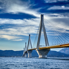 Sunset view on the bridge near Patras. Suspension bridge crossing Corinth Gulf strait, Greece, Europe. Second longest cable-stayed bridge in the world. Dramatic red sky under a Rion-Antirion Bridge.