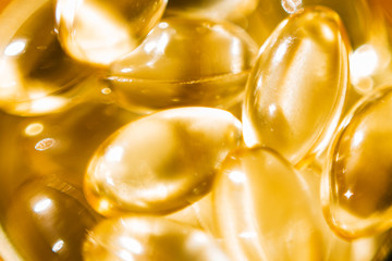 Macro shot of fish oil vitamin d transparent capsules. Dietary supplements.