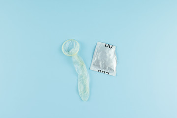 Used condom on blue background. Healthcare, safe sex and love concept