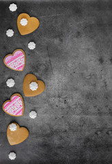 Fototapeta premium Mother's Day, Valentine's Day, Women's day.Banner of gingerbread hearts on a dark stone background with space for text.Poster for sale in the store.Postcard favorite..Spring festival.vertical