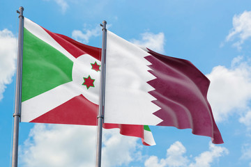 Qatar and Burundi flags waving in the wind against white cloudy blue sky together. Diplomacy concept, international relations.