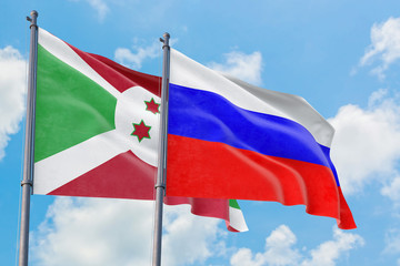 Russia and Burundi flags waving in the wind against white cloudy blue sky together. Diplomacy concept, international relations.