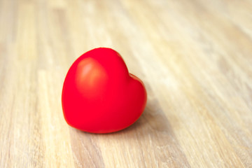 Red heart plump big volume soft on natural bleached oak wooden background close up. Copy space.