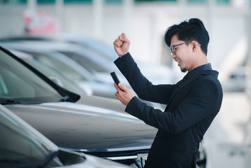 Good looking young business man in asia Show the joy that sales have been completed for the new car showroom.