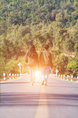 Smooth Focus,Valentine couples walking hand in hand, along the road with Golden light coming straight from the front and promised to take care of each other with love and caring. Lovers love concept.