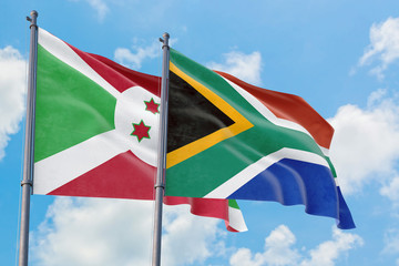 South Africa and Burundi flags waving in the wind against white cloudy blue sky together. Diplomacy concept, international relations.