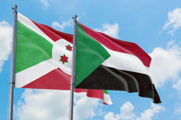 Sudan and Burundi flags waving in the wind against white cloudy blue sky together. Diplomacy concept, international relations.
