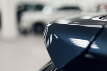 The spoiler of the car. The background is blurred. Classic blue color. Car detail. Exterior detail