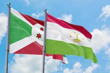 Tajikistan and Burundi flags waving in the wind against white cloudy blue sky together. Diplomacy concept, international relations.