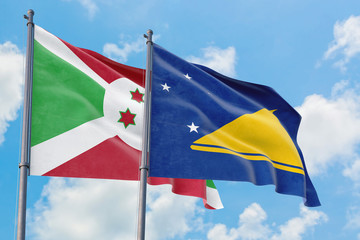 Tokelau and Burundi flags waving in the wind against white cloudy blue sky together. Diplomacy concept, international relations.