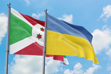 Ukraine and Burundi flags waving in the wind against white cloudy blue sky together. Diplomacy concept, international relations.