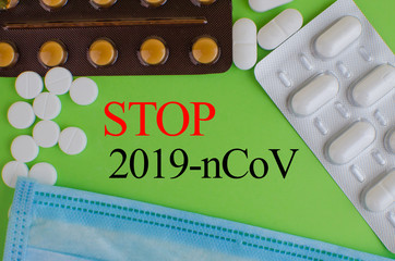 Text phrase Coronavirus on a green background with medicines and protective masks. Novel...