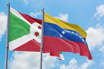 Venezuela and Burundi flags waving in the wind against white cloudy blue sky together. Diplomacy concept, international relations.