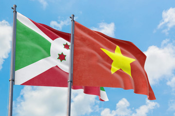 Vietnam and Burundi flags waving in the wind against white cloudy blue sky together. Diplomacy concept, international relations.