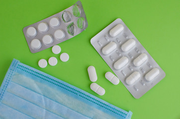 Text phrase Coronavirus on a green background with medicines and protective masks. Novel coronavirus 2019-nCoV.