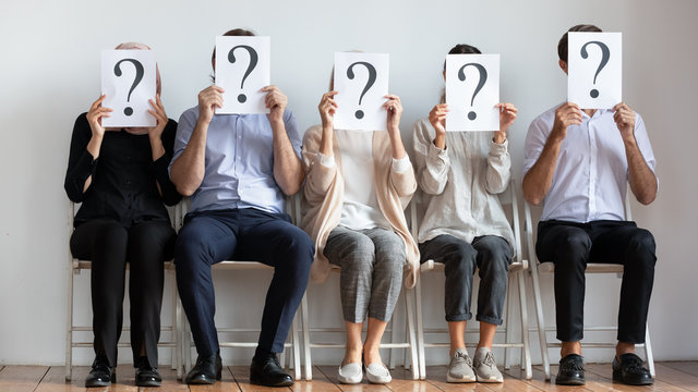 Diverse employees hold sheets with question marks wait for interview