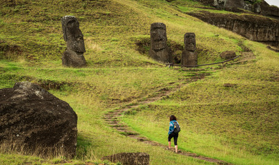 Unrecognizable tourist woman hiking along moais in rpa nui