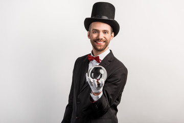 professional magician holding magic ball, isolated on grey