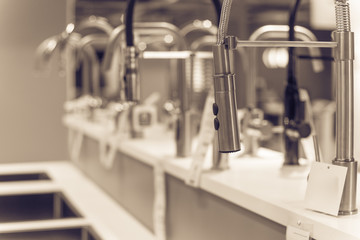 Shiny kitchen faucets with pull-out sprout at furniture showroom in Texas, USA