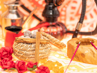 Still life consisting of hookah, flowers, figs, cinnamon, candles and tea-making utensils